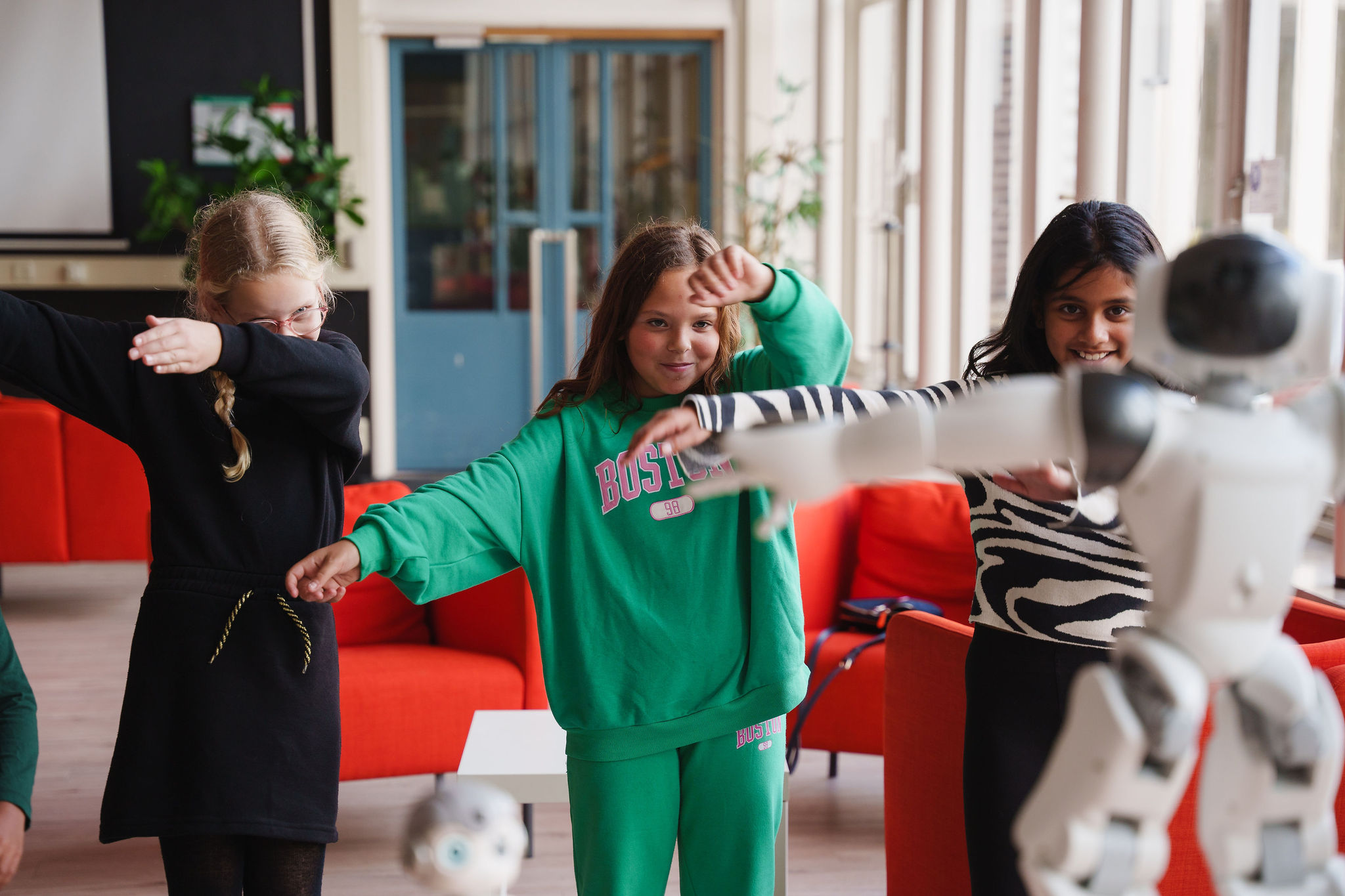 3 meisjes dansen met een robot in de klas